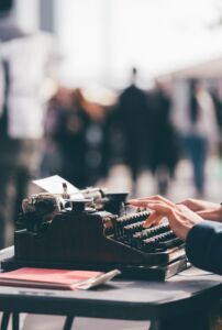 A person typing on an old fashioned typewriter.