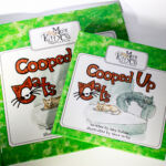 CoopCatsSAL2 Two books about cats are sitting on a table.