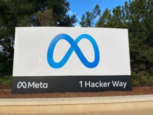 Meta sign at the company’s Menlo Park headquarters, showing the Meta logo and “1 Hacker Way.”